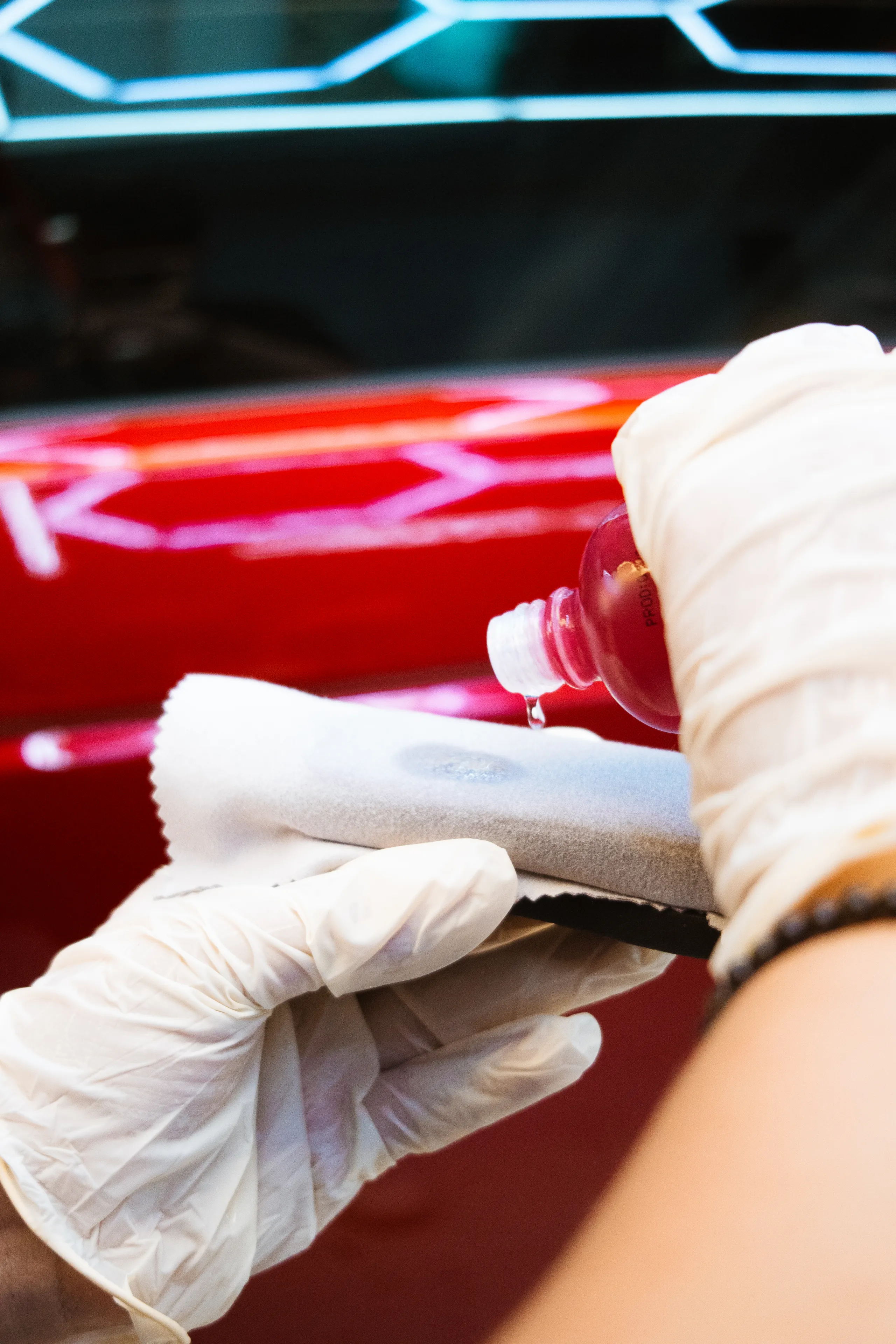 Aplicación de cerámico sobre pintura roja con reflejos de luces hexagonales