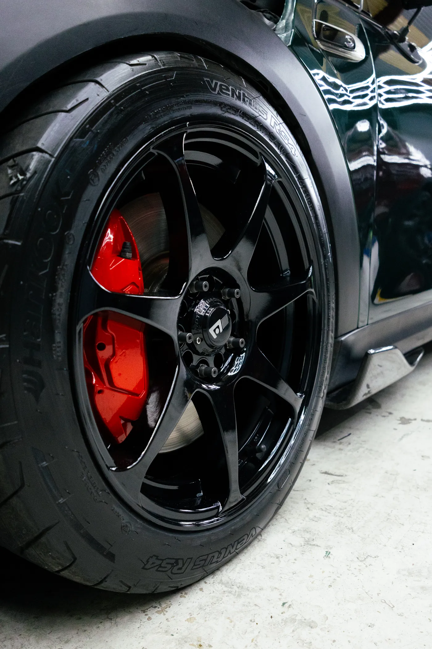 Detalle de la rueda y la carrocería de un automóvil en el taller